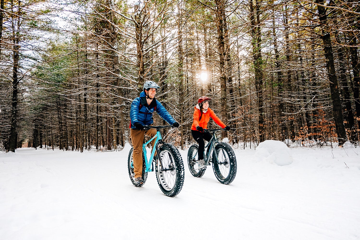 2 people mountain biking in the snow