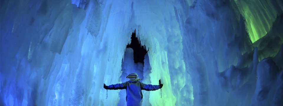 Child walking through a cave made of ice at the Lincoln Ice Castles