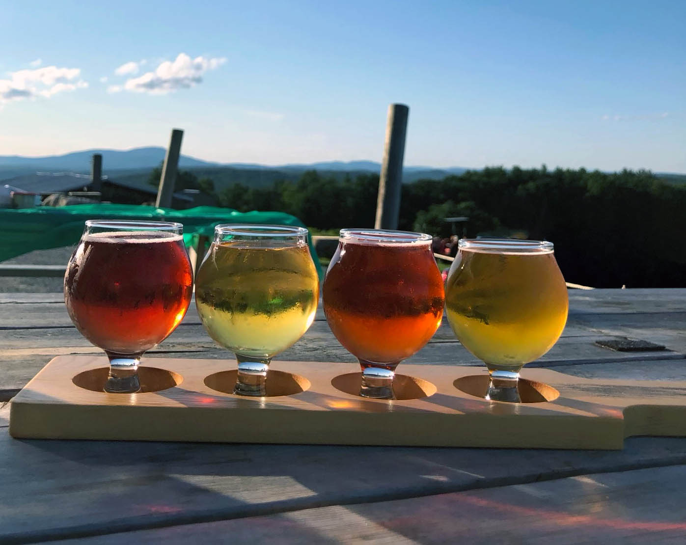 a flight of cider on a wooden table