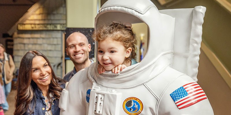child at museum in a spacesuit