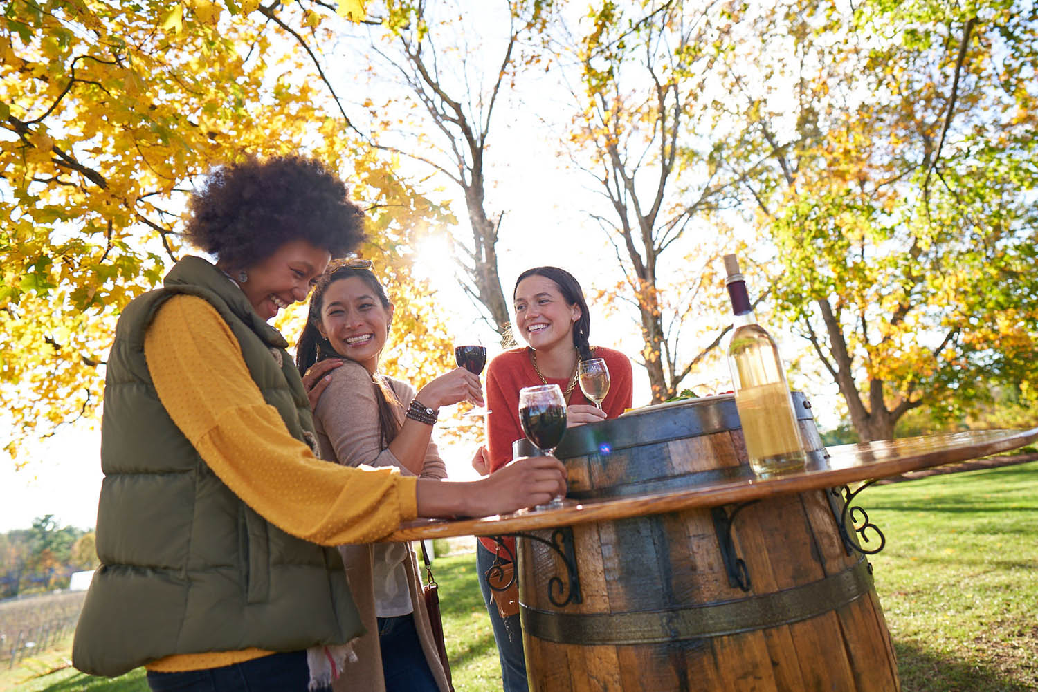 Woman outdoors gathered around a table wine tasting