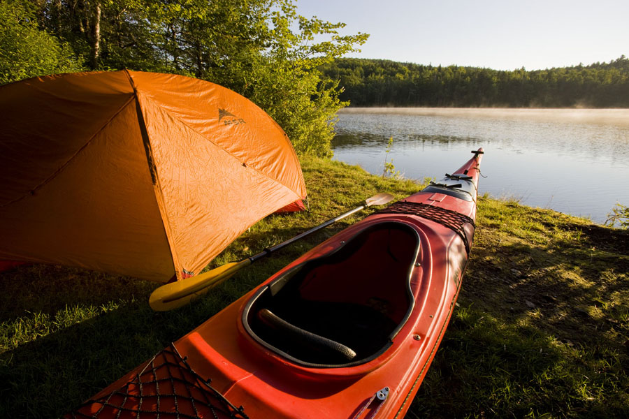 Tent and kayak by river