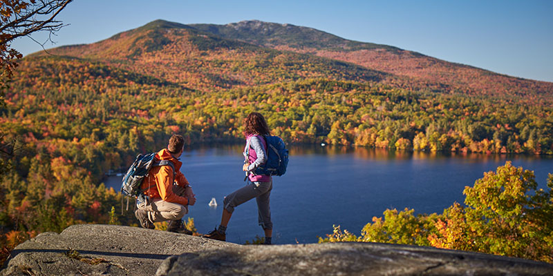 Couple hiking overlooking fall foliage