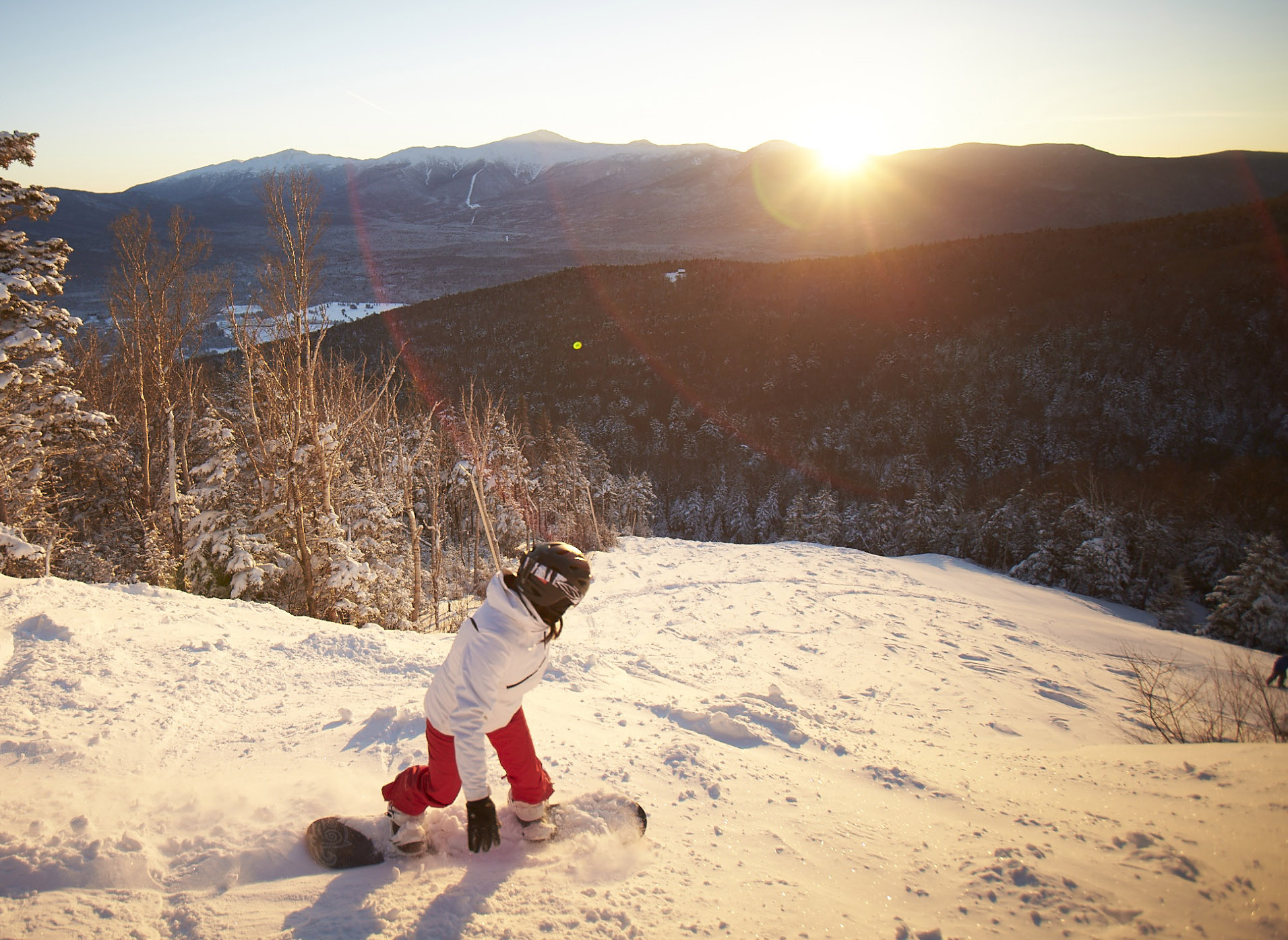 a snowboarder at sunset
