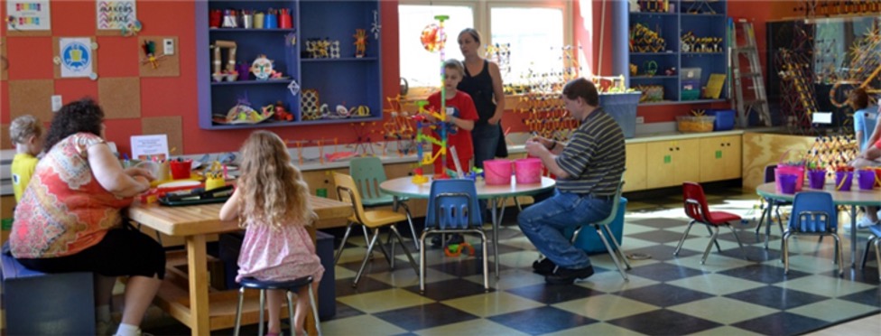 Woman and children playing at the table at Children's Museum of New Hampshire