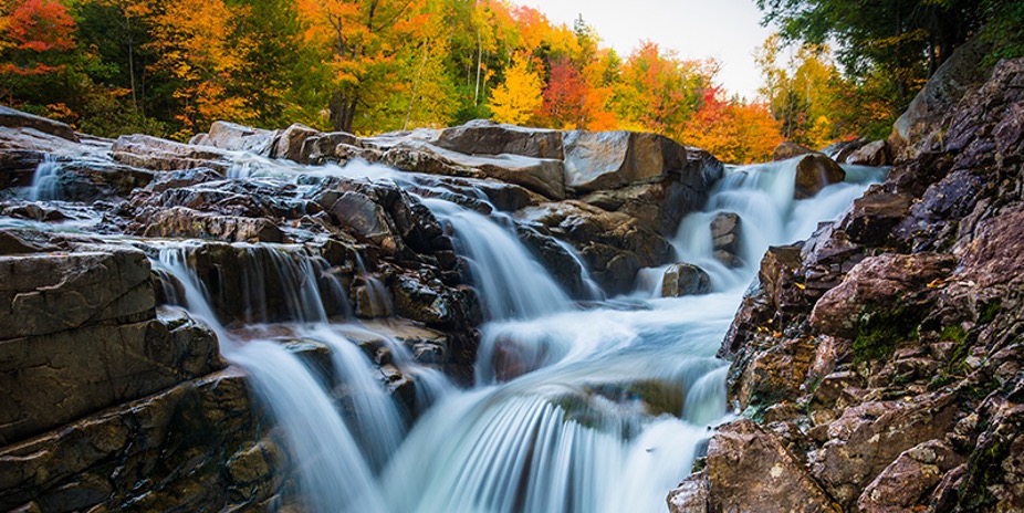 Image of small waterfalls on The White Mountain Trail with fall foliage in the background