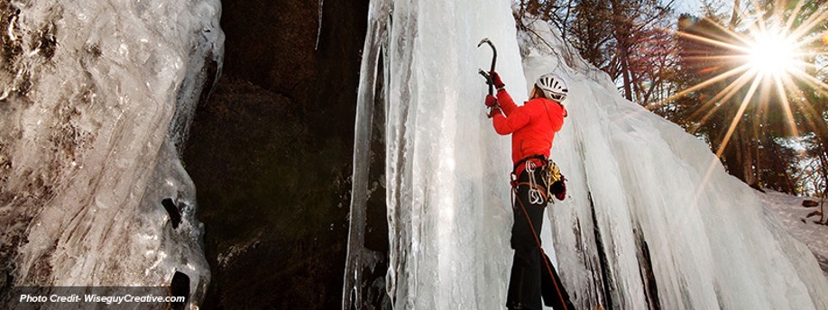 Woman climbing up ice at Mount Washington Valley Ice Fest